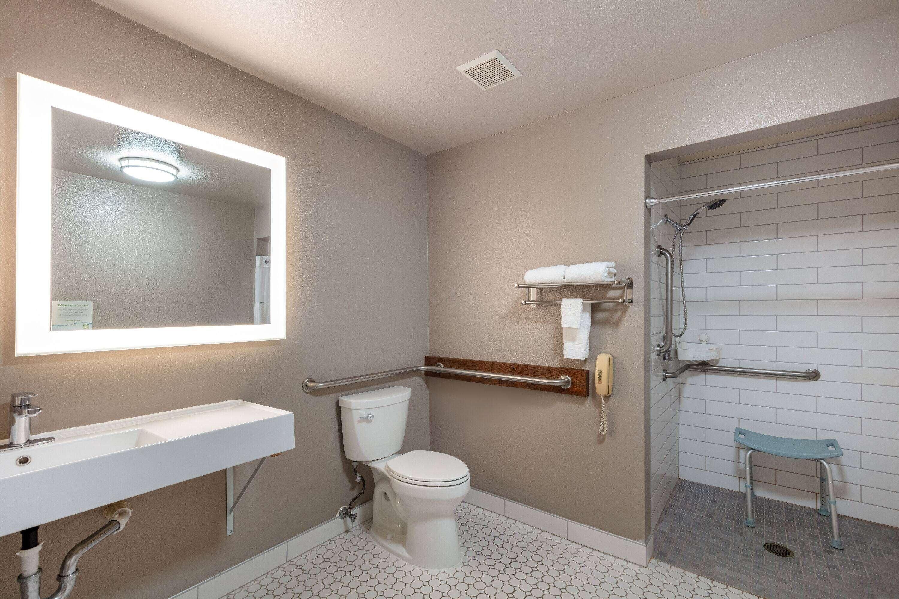A bathroom with a white sink, toilet, and shower area.