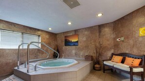 Un área de spa con un jacuzzi, una banca de madera y un cuadro en la pared.