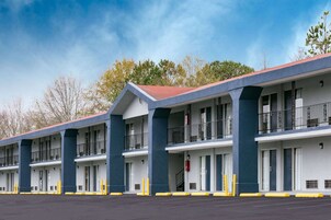 Un motel con varias unidades de dos pisos, cada una con balcones y techo rojo.