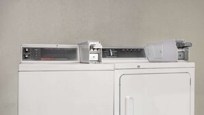 A white commercial washer with a Speed Queen label and a control panel. - Super 8 by Wyndham Locust Grove (Locust Grove)