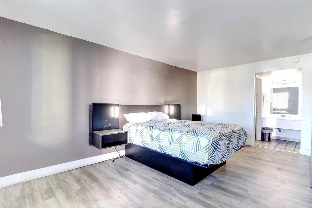 A modern bedroom with a bed, bedside tables, and a built-in bench.