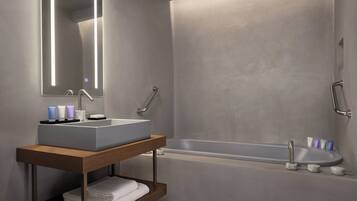 Un baño moderno con un lavamanos rectangular, un espejo y una bañera.