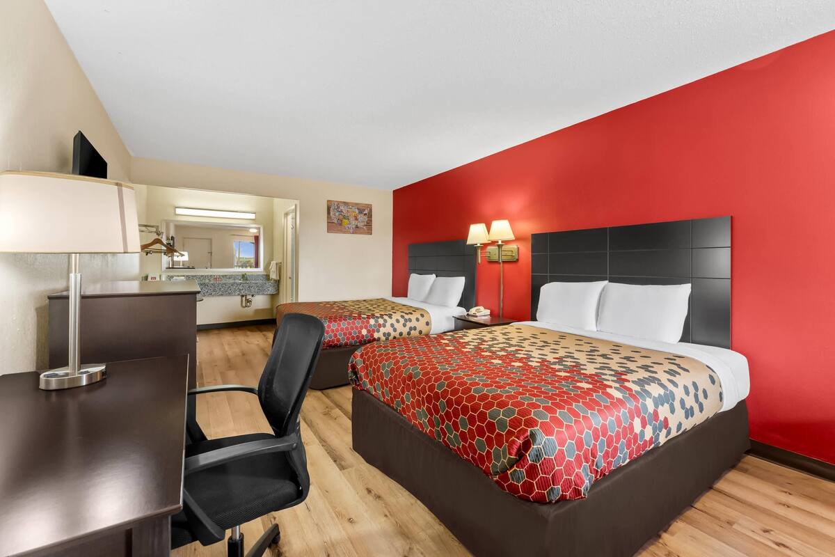 Una habitación de hotel con dos camas, un escritorio y una silla.