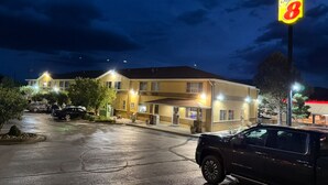 Un motel avec une enseigne « Super 8 », un parking et un bâtiment doté de nombreuses fenêtres et de balcons.