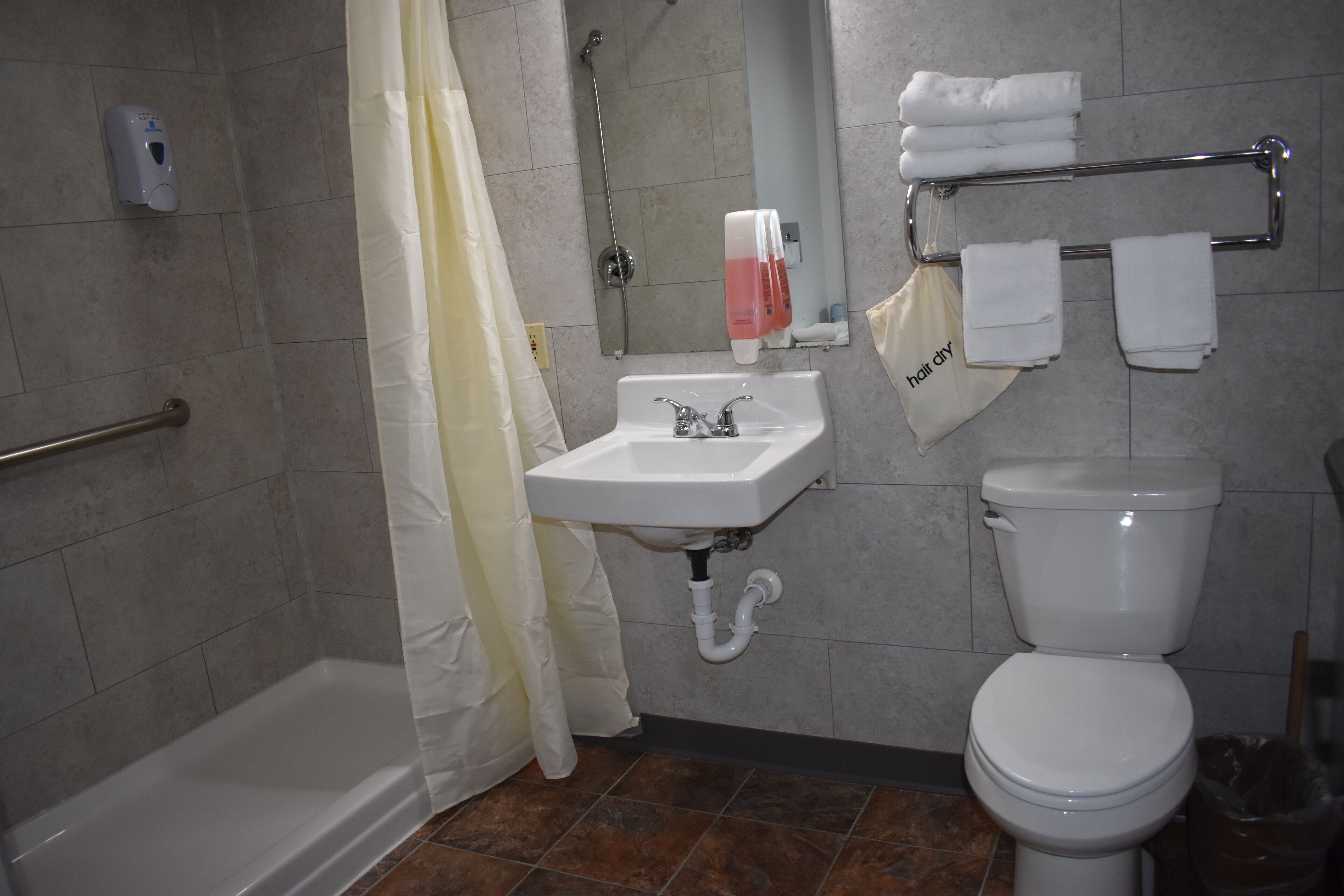 A bathroom with a bathtub, sink, toilet, and towel rack.