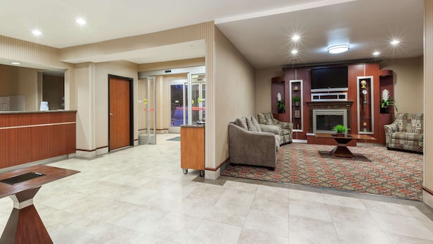 A hotel lobby with a reception desk, seating area, and a fireplace. - Travelodge by Wyndham Sylmar CA (Sylmar)