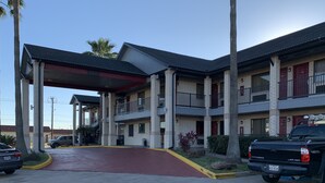 A motel with a covered entrance, multiple floors, and a parking area. - Americas Best Value Inn Houston Hobby Airport (Houston)