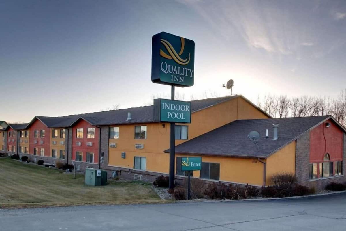 A Quality Inn with an indoor pool, multiple-story buildings, and a clear sky.