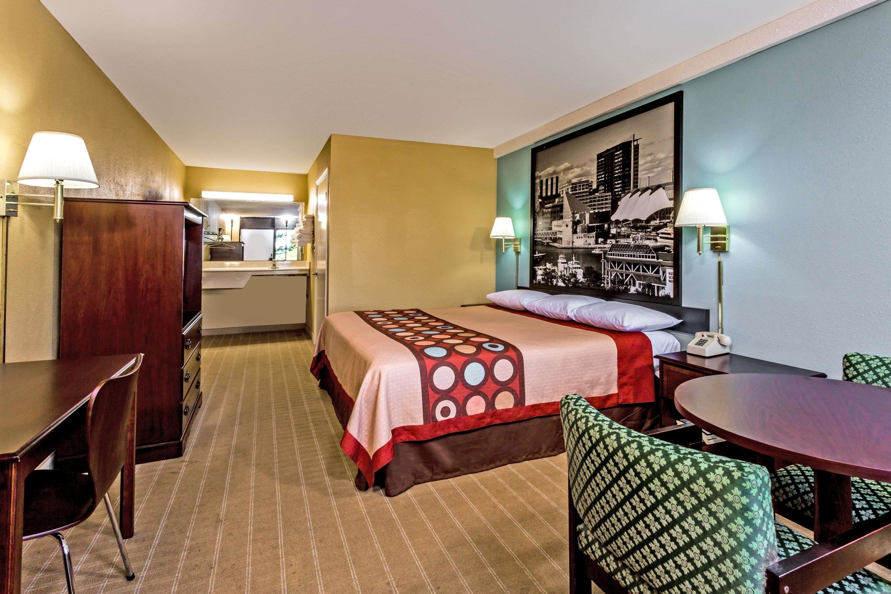 Une chambre d’hôtel comprenant un lit, un bureau, une chaise, une table à manger et un coin cuisine.