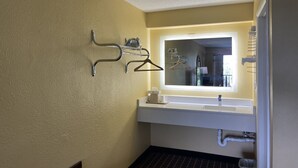 A bathroom with a white sink, a mirror, and a towel rack.