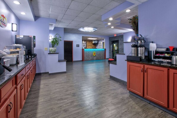 A hotel lobby with a reception desk, a coffee station, and a plant. - Super 8 by Wyndham Mobile/Tillmans Corner (Mobile)