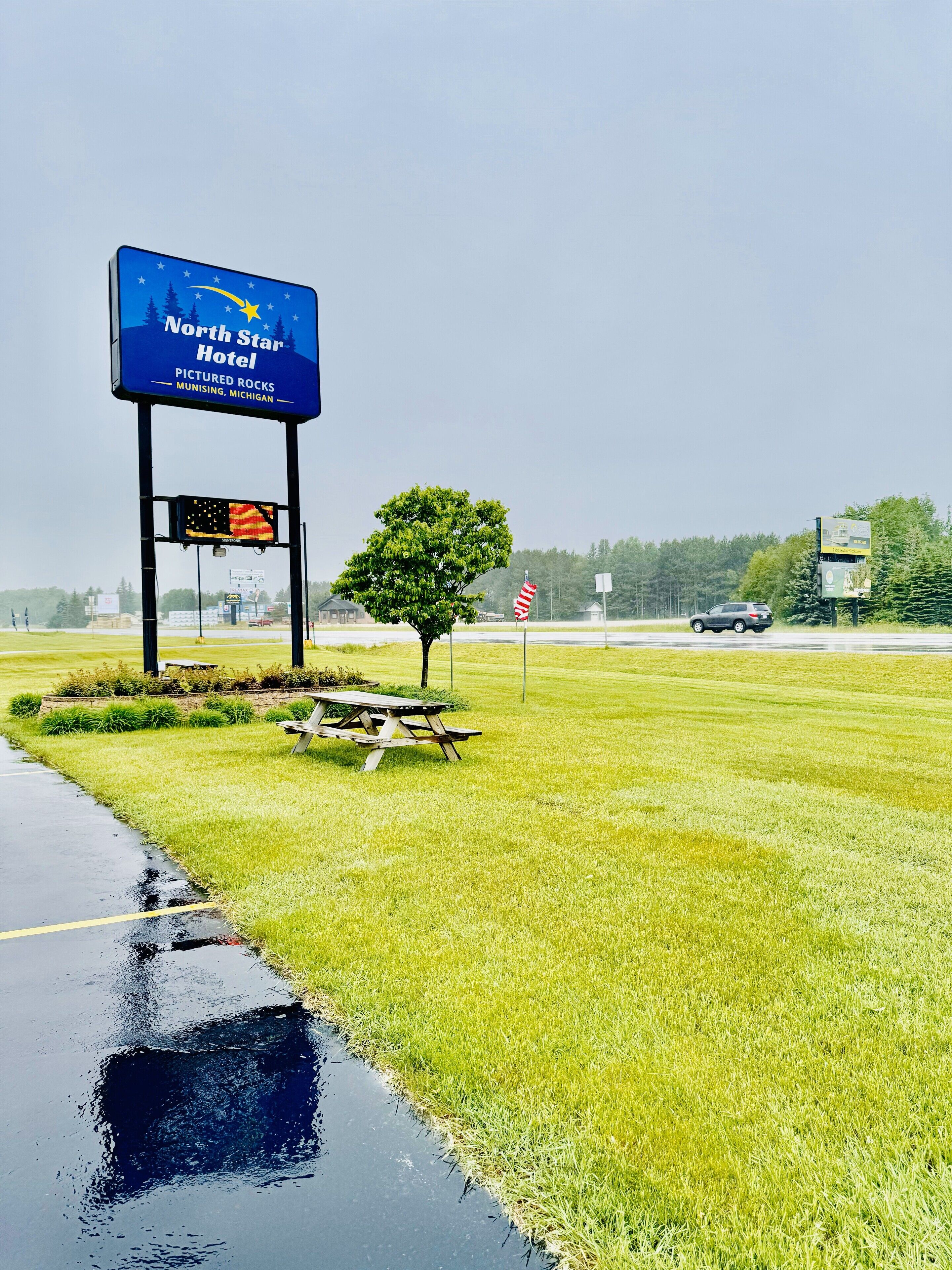A North Star Hotel sign with a picnic table and American flag in a grassy area.