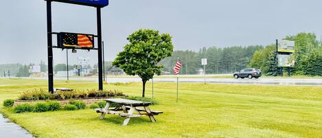 A North Star Hotel sign with a picnic table and American flag in a grassy area.