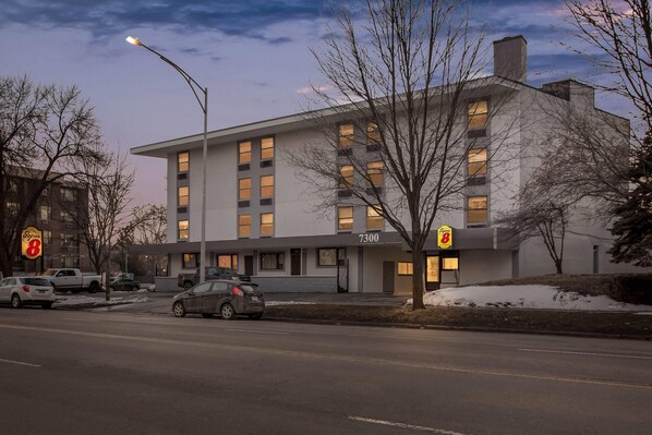 A modern building with multiple windows and a sign indicating it is a Super 8 hotel.