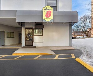 Entrada d'un hotel Super 8, amb vista clara a la zona d'aparcament i un carrer cobert de neu.