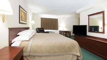 Une chambre d’hôtel avec un grand lit, un bureau, une chaise, une télévision et un miroir.