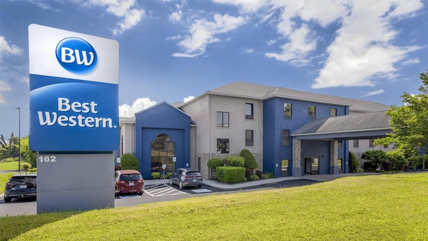 Un hôtel Best Western avec une enseigne bleue et blanche, un parking et un bâtiment doté d’un toit gris.