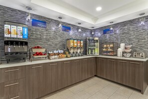 A modern breakfast bar with juice dispensers, a selection of cereals, and a variety of breakfast items.