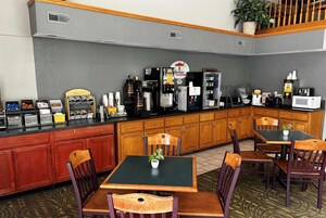 A breakfast area with a coffee machine, microwave, and seating.