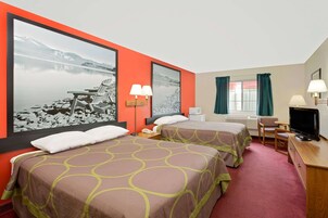 A hotel room with two beds, a TV, a desk, and a window with curtains.