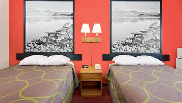 Una camera d'hotel con due letti, un comodino, una lampada e due quadri di grandi dimensioni raffiguranti un paesaggio lacustre.