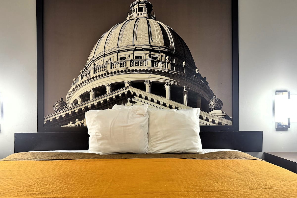 Ein Bett mit einem großen Poster, das die Kuppel und Säulen eines prächtigen Gebäudes zeigt.