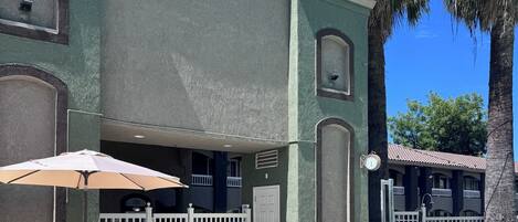 Edificio Travelodge con piscina, mobiliario exterior y valla blanca.