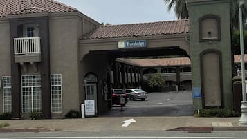 A Travelodge hotel with a tiled roof, a balcony, and a sign indicating it is a top-rated hotel in the region.