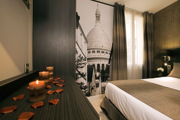 A hotel room with a large bed, a wall-mounted TV, and a wall with a cityscape mural. - Hotel Eden Opéra (Paris)