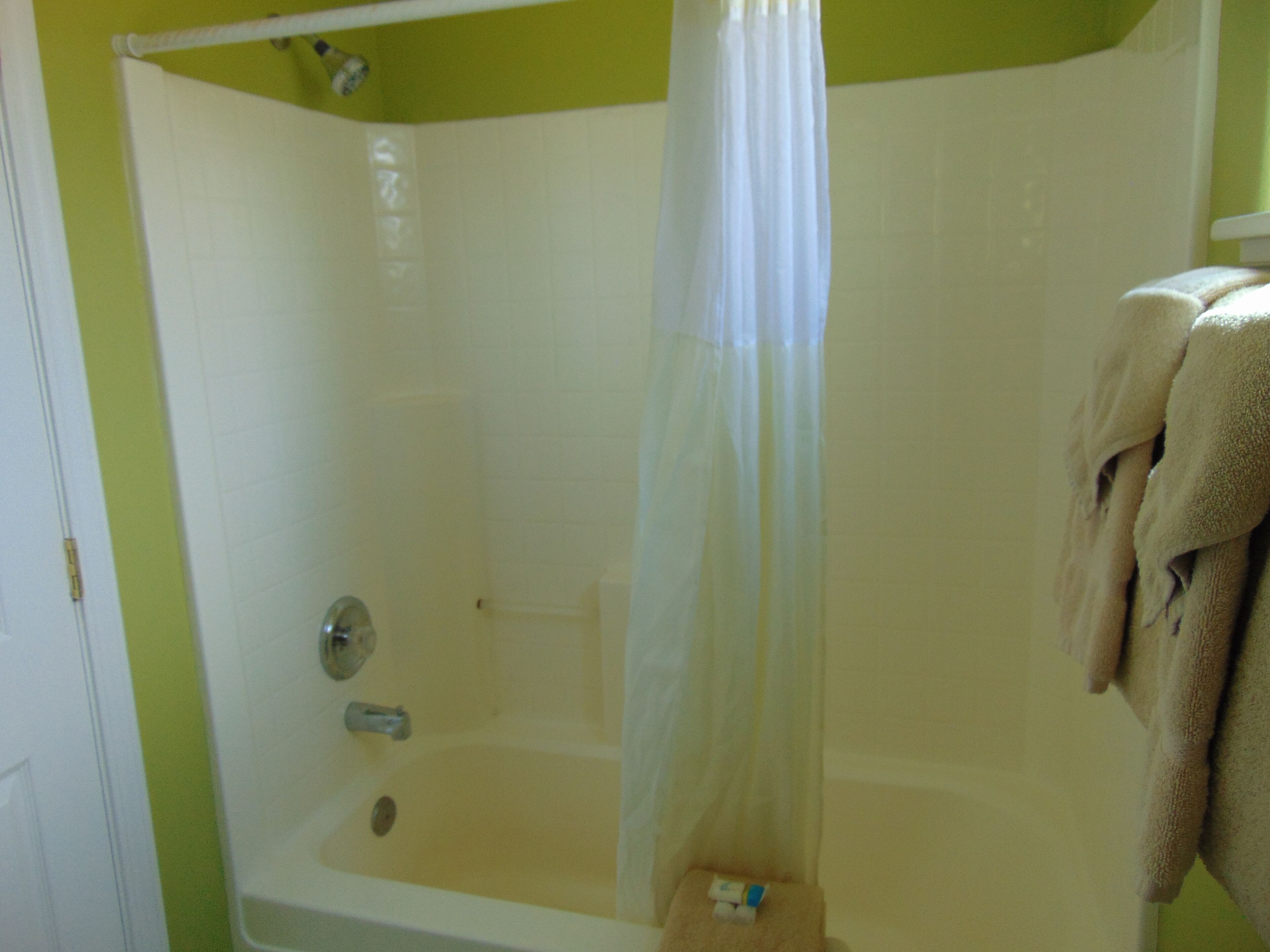Un baño con bañera, cortina de ducha y barra para toallas.