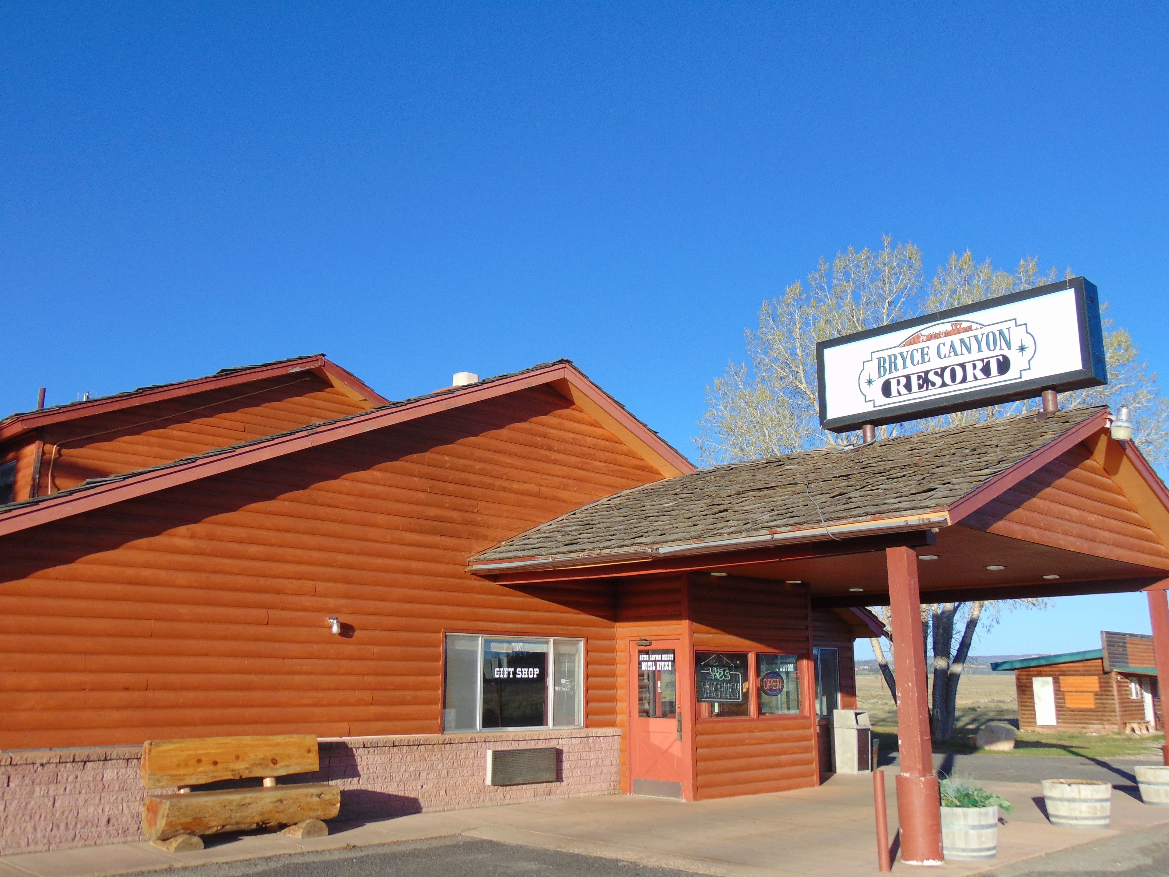 A rustic wooden building with a sign for Bryce Canyon Resort.