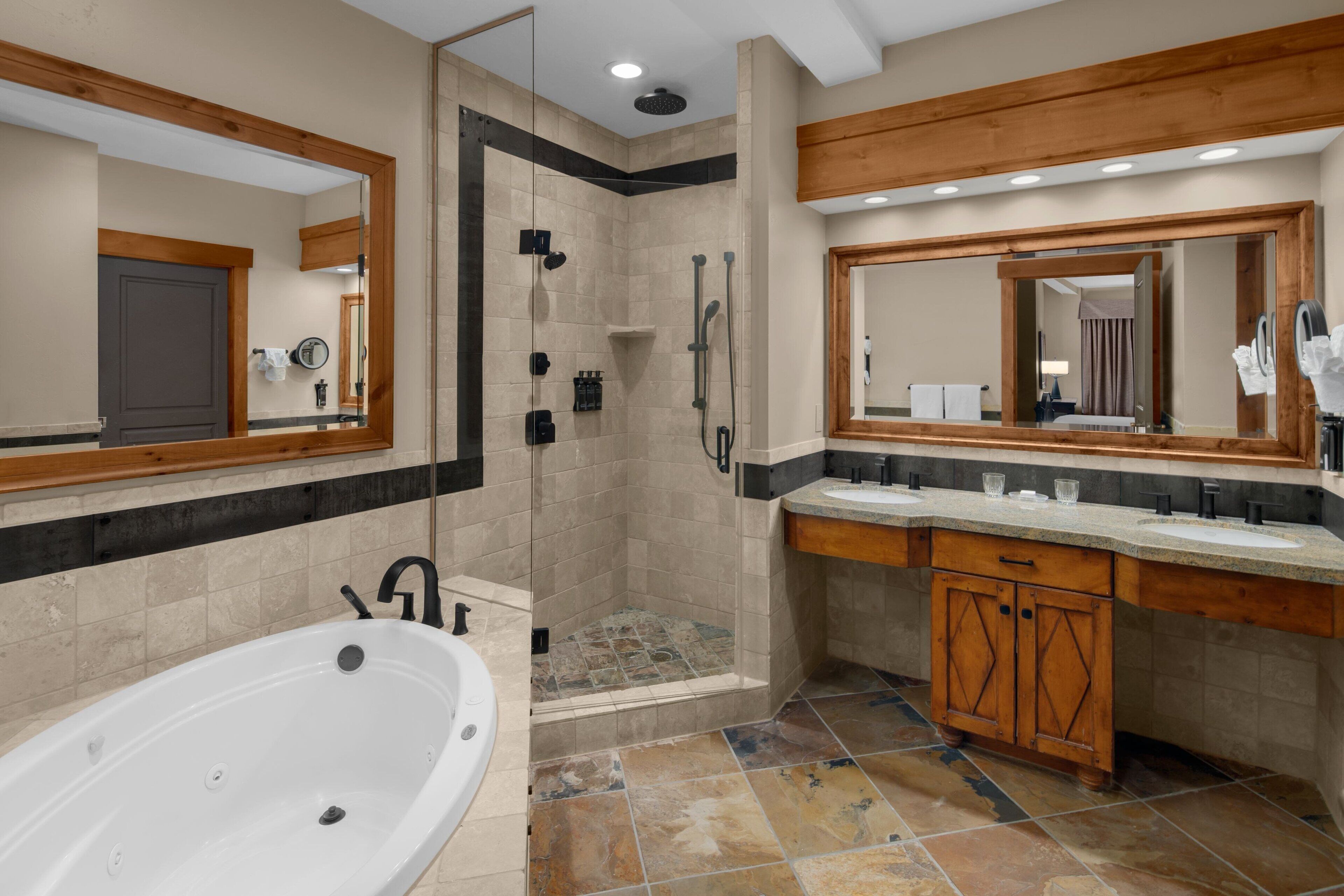 Un baño moderno con cabina de ducha, bañera y tocador con espejo.