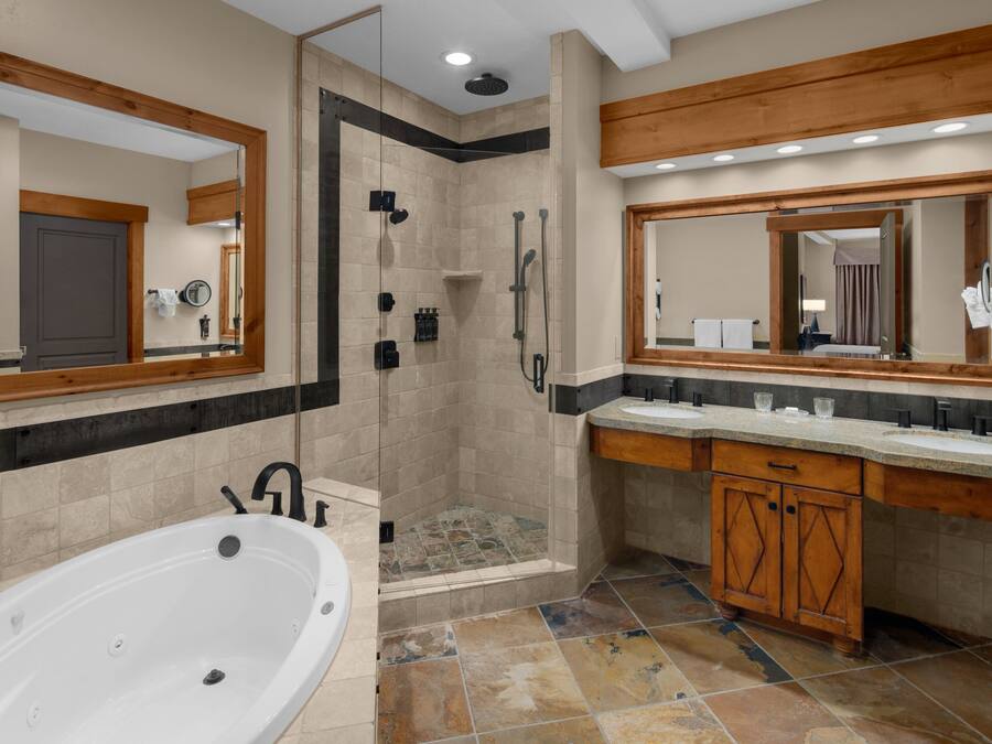 Un baño moderno con cabina de ducha, bañera y tocador con espejo.