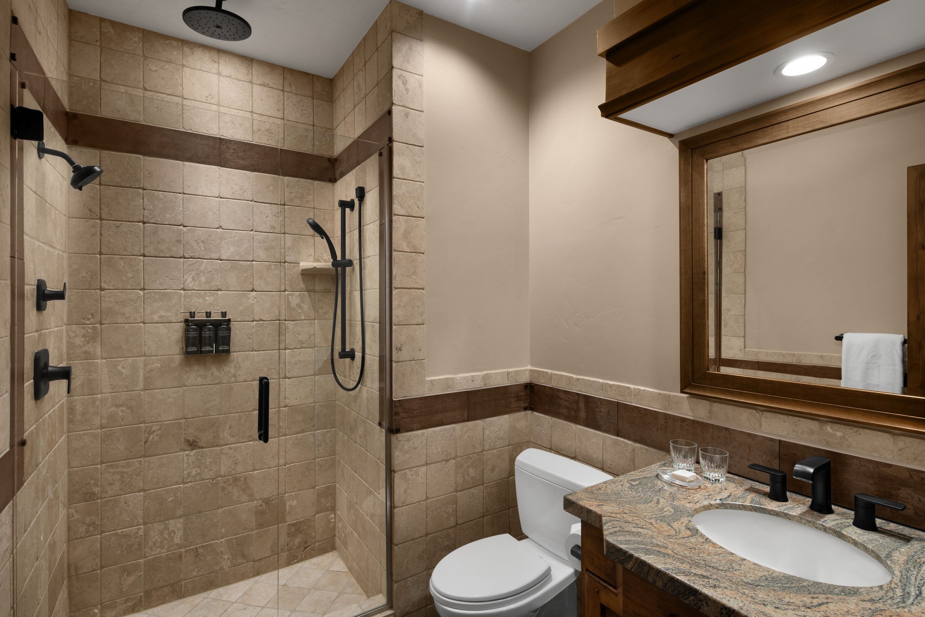 A bathroom with a shower, toilet, and sink.
