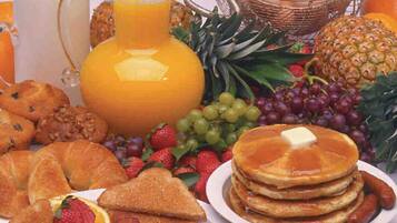 A breakfast spread with pancakes, eggs, toast, and fruit.