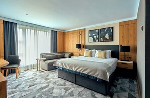 A hotel room with a bed, a sofa, a desk, and a chair. - Crowne Plaza Hotel Marlow by IHG (Marlow)