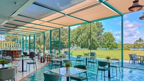 An outdoor patio area with tables and chairs, a pool, and a view of the surrounding landscape. - Crowne Plaza Hotel Marlow by IHG (Marlow)