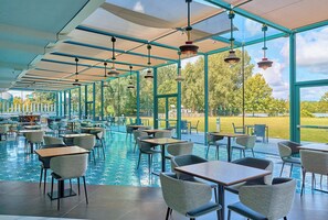 An indoor dining area with tables and chairs, a pool, and a view of the outdoors. - Crowne Plaza Hotel Marlow by IHG (Marlow)