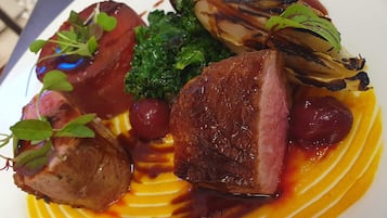 Un plato con varios tipos de carne, verduras y salsas.