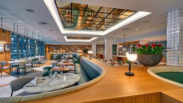 Un interior moderno con una zona de estar central, un bar y una sección de comedor.