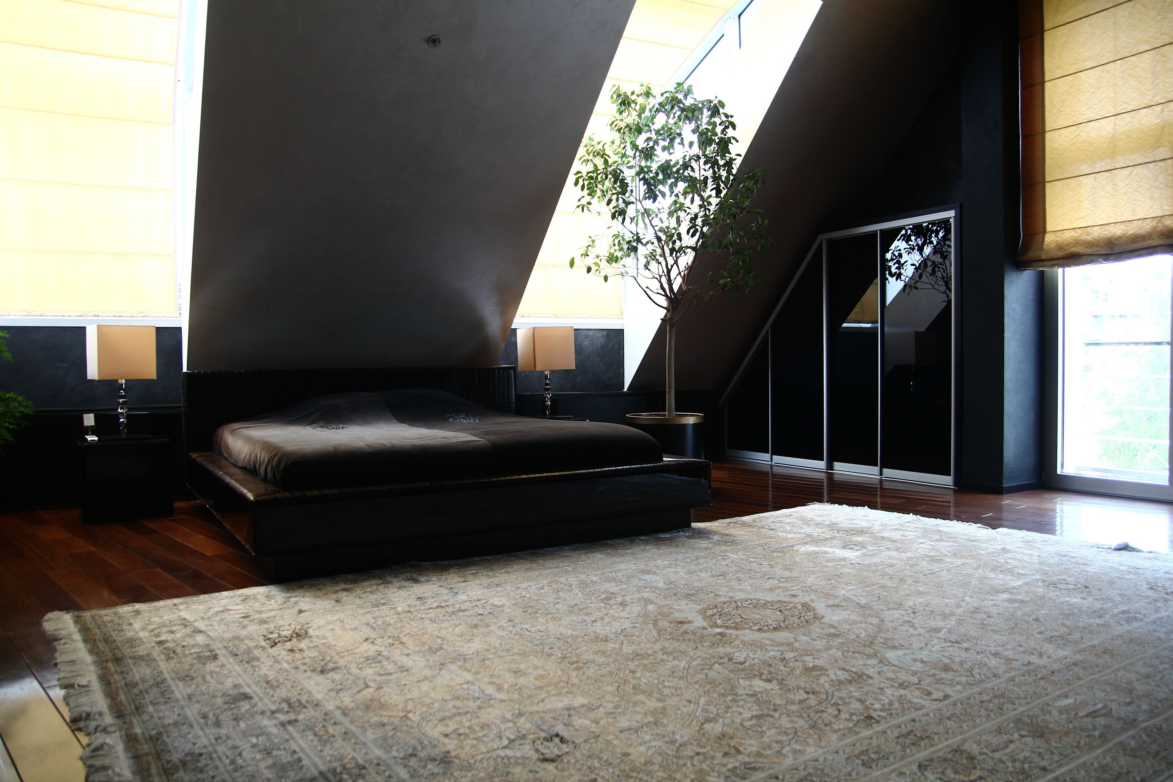 Un dormitorio moderno con una cama grande, un tragaluz y vistas al exterior.
