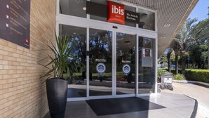 The entrance of ibis hotels with a sign indicating a 50-minute parking limit.