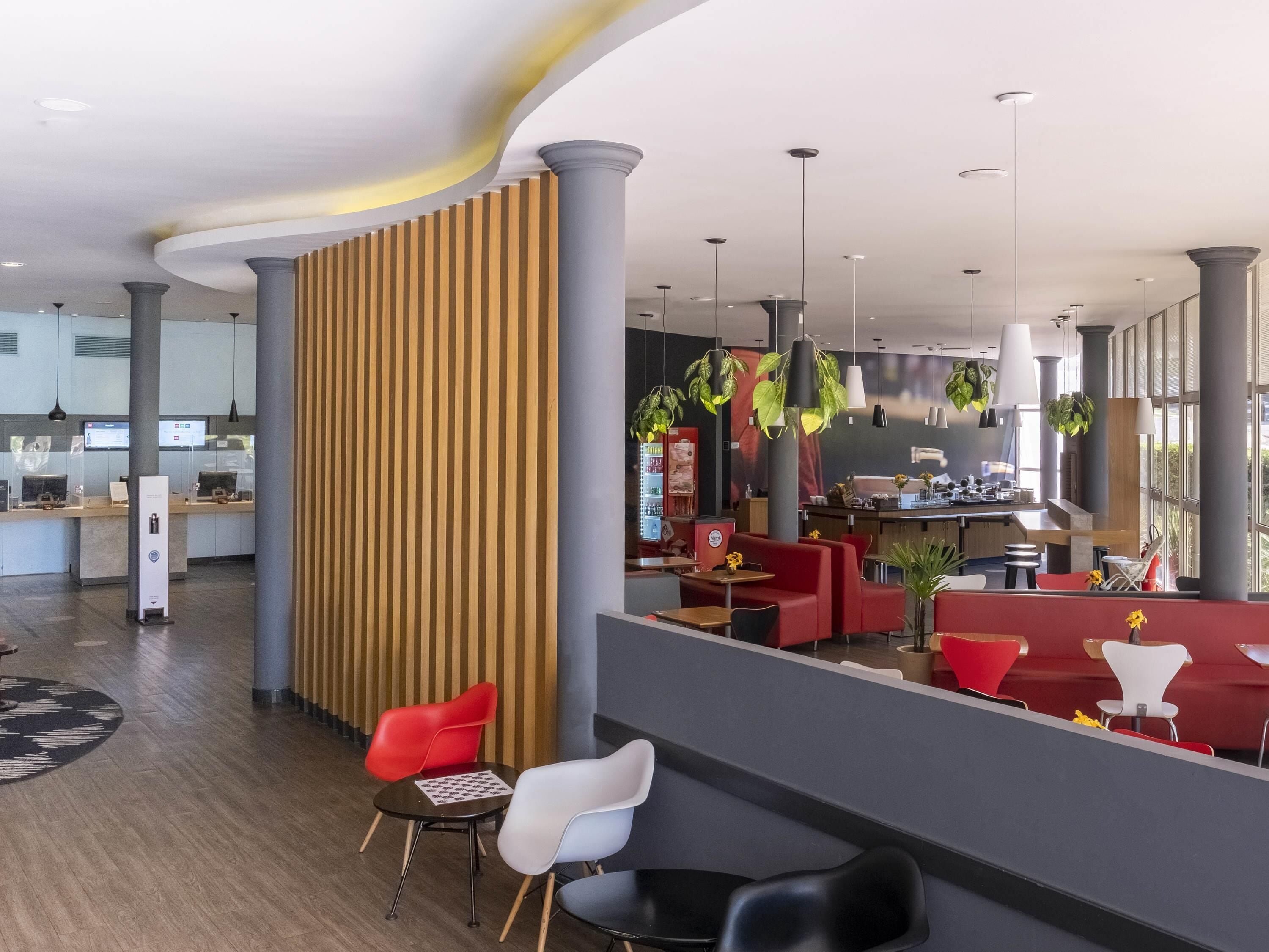 A modern interior with a reception desk, seating area, and a bar.