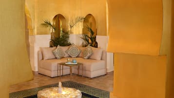 A cozy lounge area with a sofa, a coffee table, and a decorative fountain.