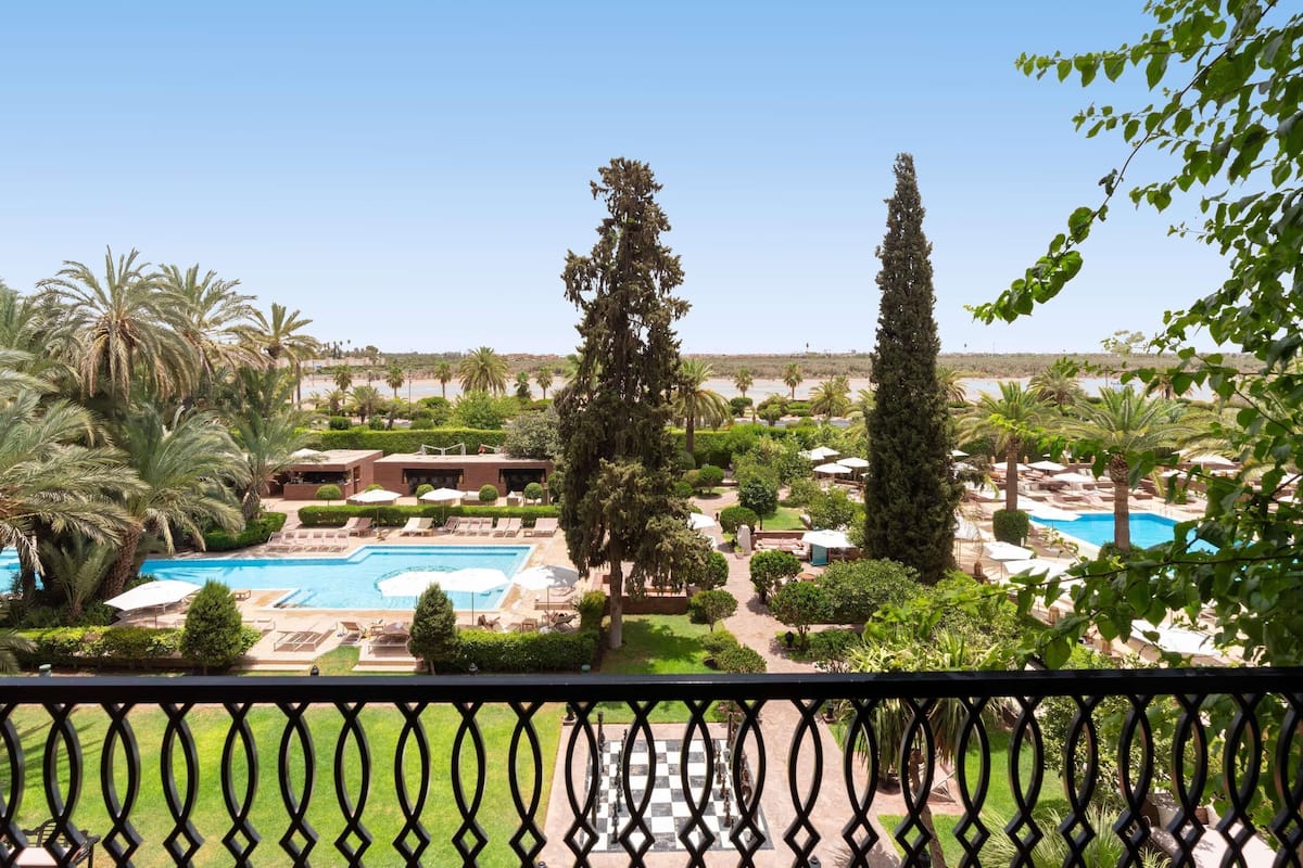 A resort with a swimming pool, lounge chairs, and a view of the beach.