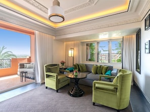 A living room with a sofa, two armchairs, a coffee table, and a view of the outdoors. - Sofitel Marrakech Palais Imperial & Spa (Marrakech)