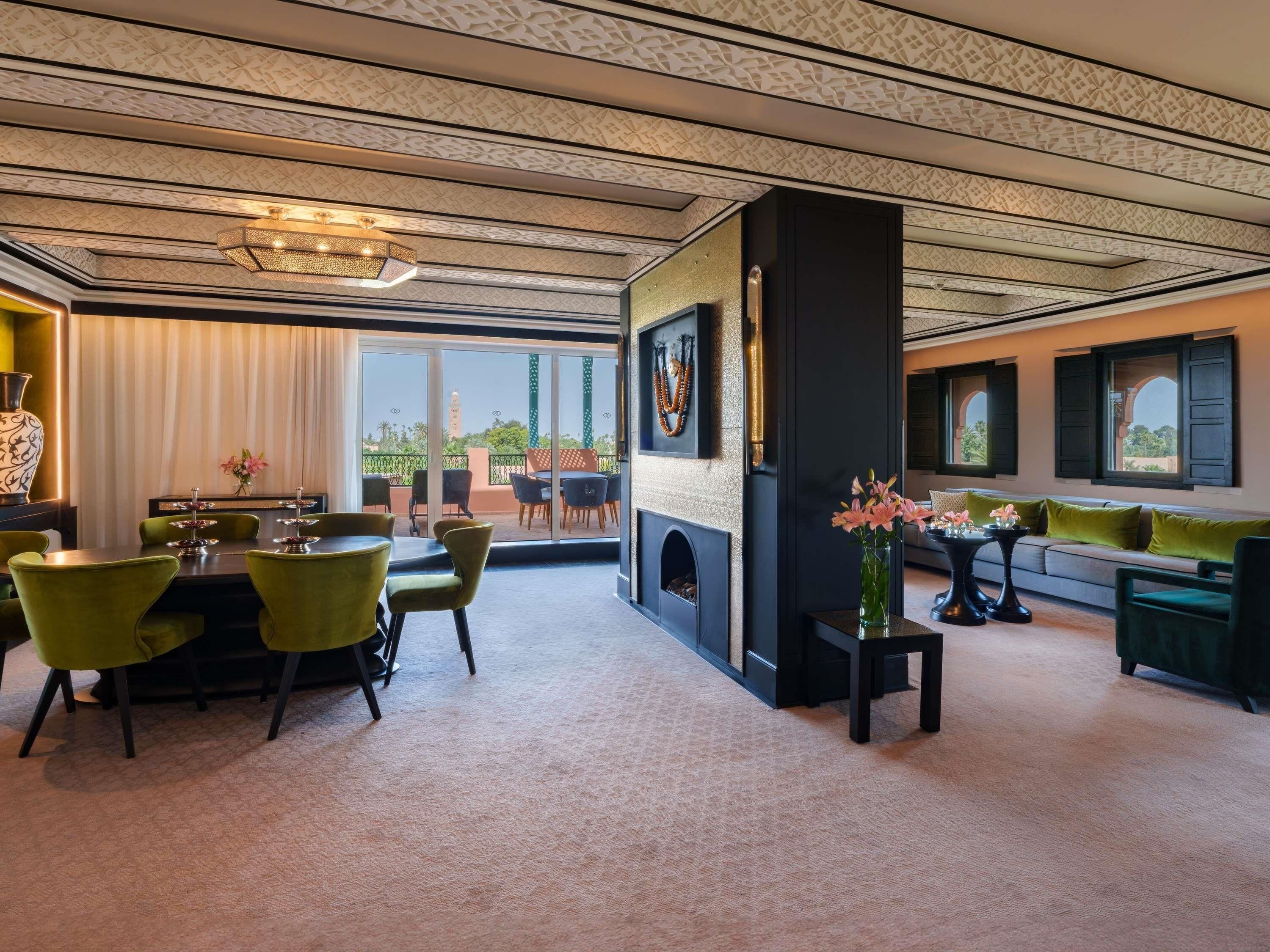Una habitación con comedor, chimenea, sofá y vistas al exterior.