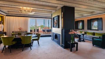 Una habitación con comedor, chimenea, sofá y vistas al exterior.
