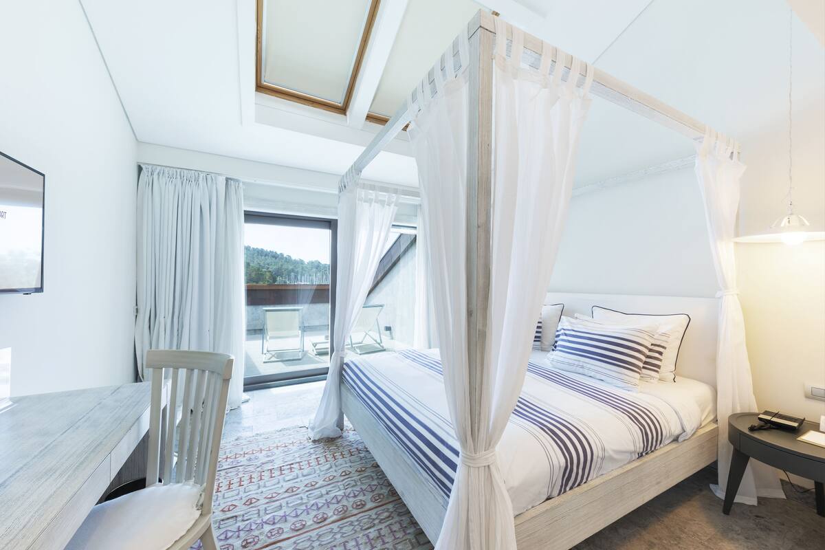 Ein Schlafzimmer mit einem Himmelbett, einem Schreibtisch und einem Stuhl.