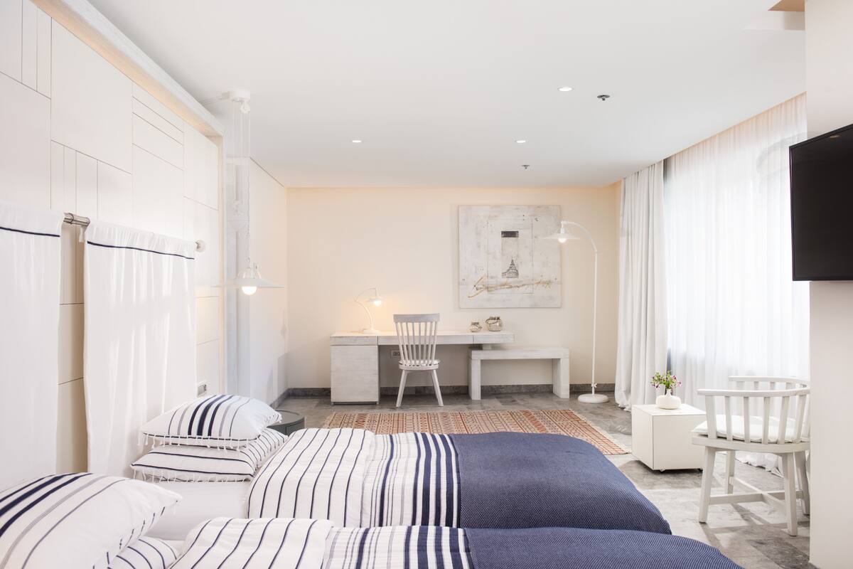 Ein modernes Hotelzimmer mit einem großen Bett, einem Schreibtisch und einem Fernseher.